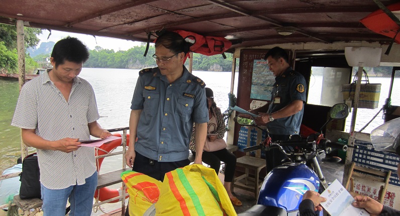 崇左市港航部门工作人员在渡口渡船发放宣传资料.jpg