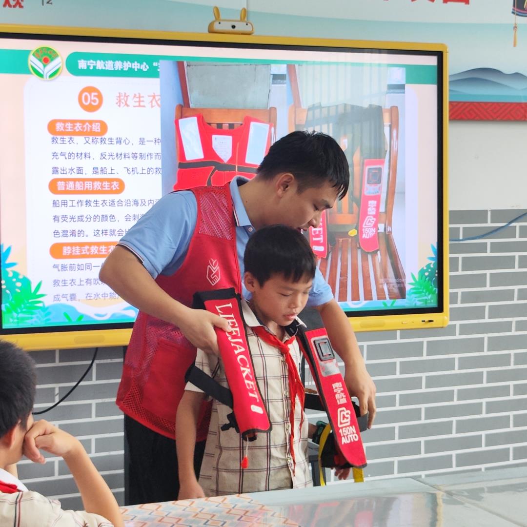 志愿者教学生如何正确穿戴救生衣（彭党鑫摄）.jpg