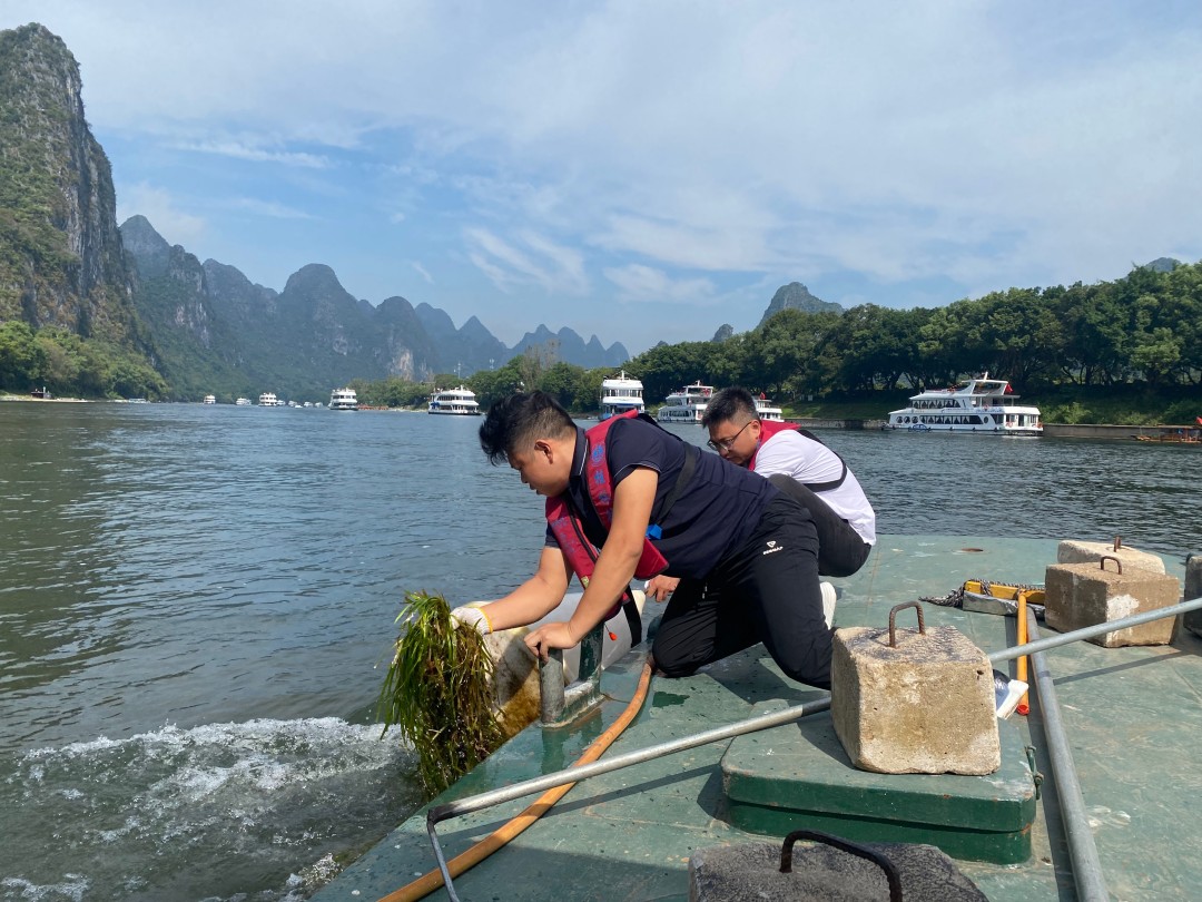 1760171598315084182.jpg 大圩航道站航标工巡航中清理附着在航标上的水草.jpg